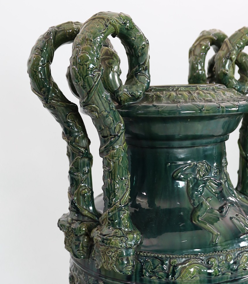 A massive Continental majolica green glazed campana vase and associated stand, late 19th century, total height 153cm, small repairs